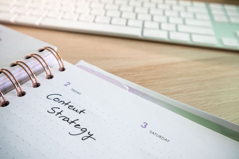 Agenda con la estrategia de contenidos para redes sociales anotada junto al teclado