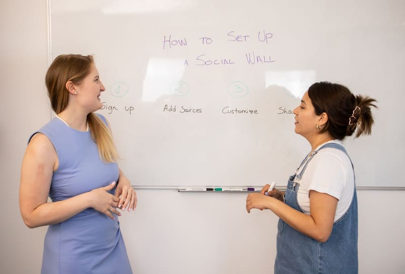 Dos community managers planificando las redes sociales de un cliente en una pizarra