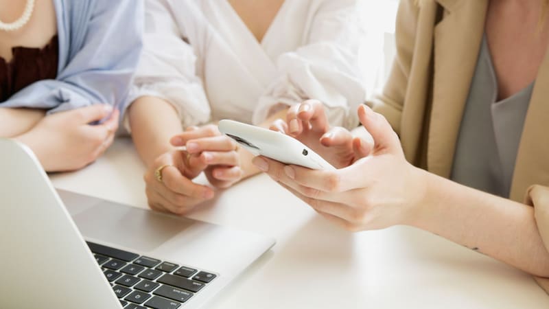 Equipo revisando la gestión de redes sociales en el móvil y en el portátil