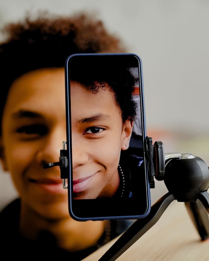 Joven grabando contenido con el móvil en un trípode