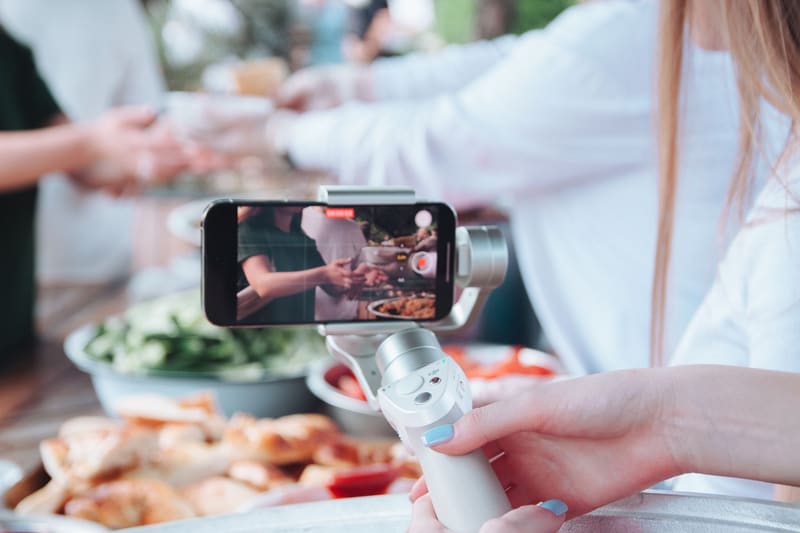 Grabación de un vídeo para redes sociales con el móvil en un estabilizador durante un evento gastronómico
